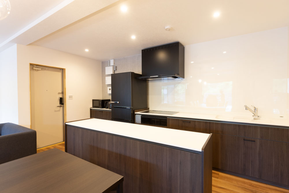 キッチンはブラウン色で落ち着きのあるもの、正面にはカウンターを設置してできた料理を置けるスペースとキッチンとダイニングを見切る意味も兼ねています。