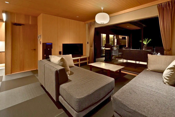 天井と壁には温かみのある木材を使用し、和モダンな雰囲気に仕上げたリビングスペース。 大きな窓の先には屋外テラスが広がり、空間全体に開放感をもたらしています。