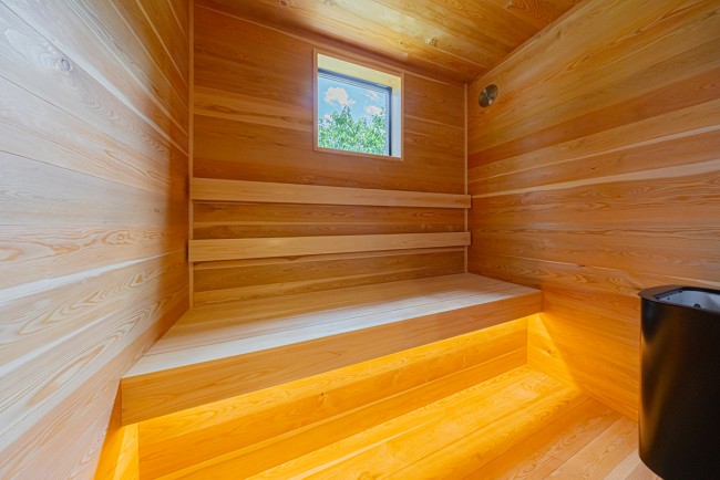 ヒノキの板張りで施工されたサウナはとてもいい匂いがします。また職人が丁寧に作った製品なのでどこか落ち着く空間に  仕上がっております。足元には間接照明も施工していますので雰囲気のある空間です。