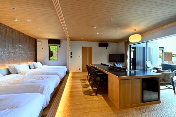 ベッド・リビング・ダイニングがひと続きになった開放的な室内。 木の質感と間接照明が、やわらかな落ち着きを演出します。