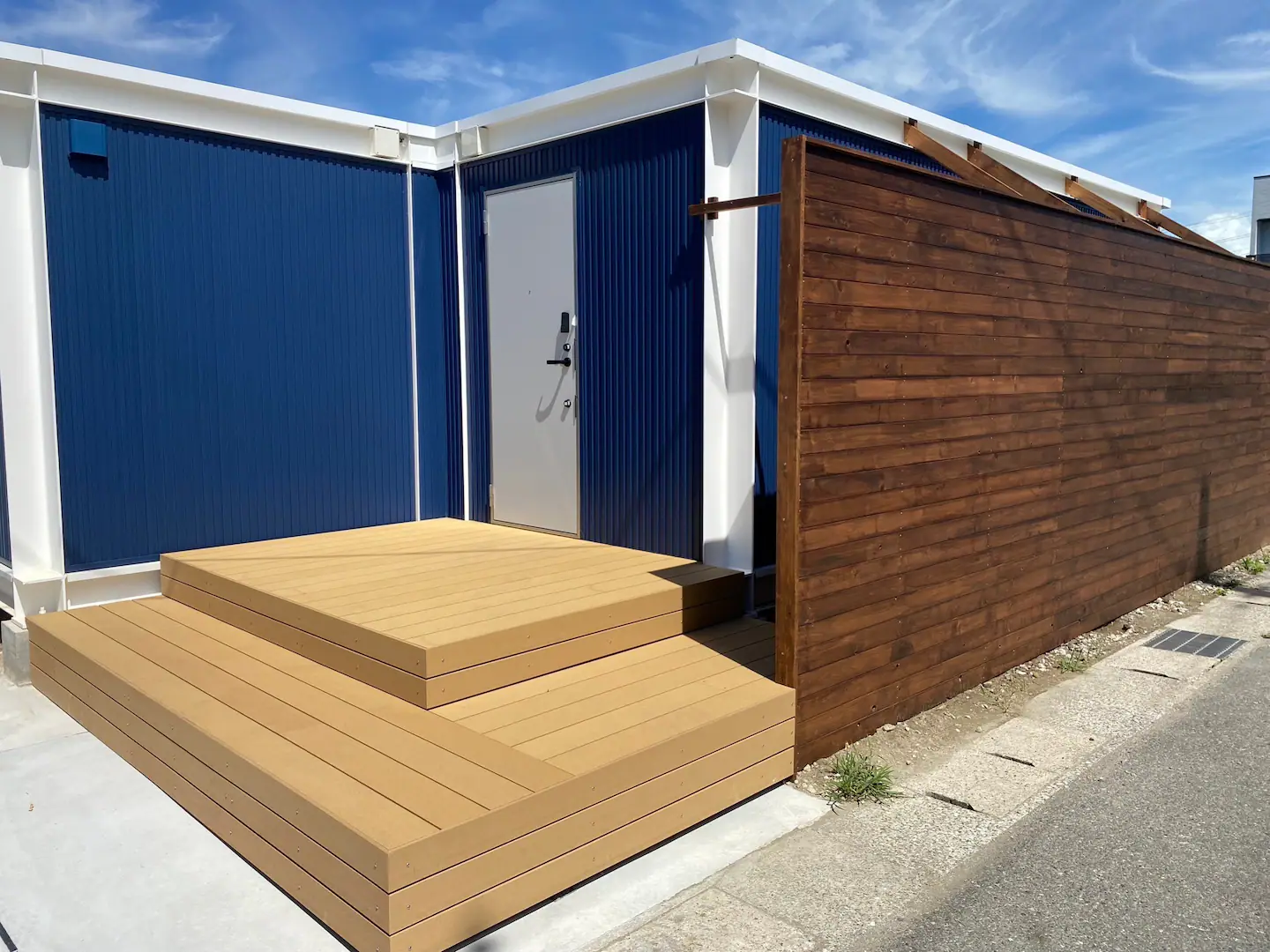 近隣に海のある環境ですのでユニットハウスの外観デザインはブルーとホワイトの柱色でアクセントで海を連想するデザインに。