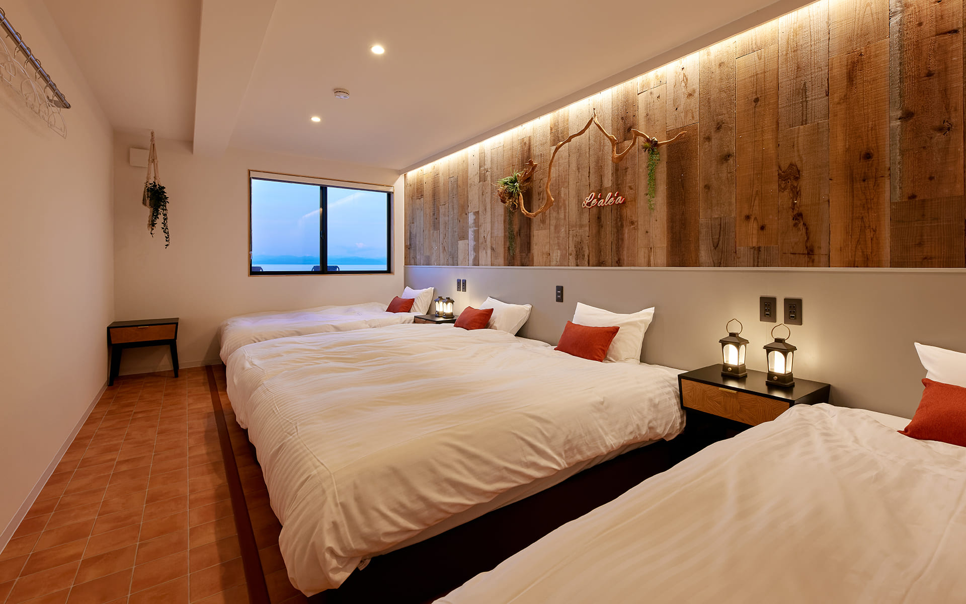 テラコッタタイル調の床に古木風の壁紙のアクセントクロス、間接照明で陰影がでていい雰囲気です。夕日をイメージいたしました。